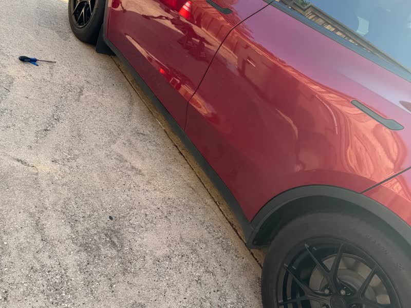 Red Tesla Model Y back on the ground with a new wheel fitted and torqued after a completed mobile EV tire service call